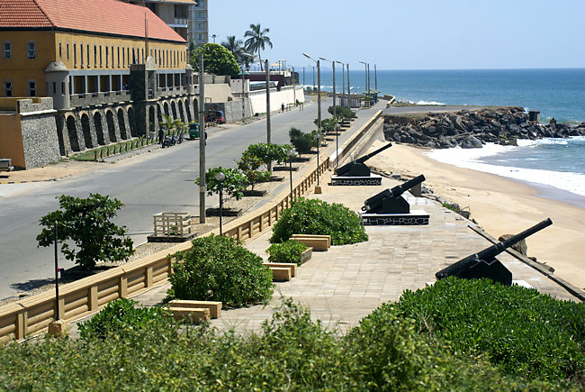 Colombo Fort Marine Drive - Chaitya Road in Sri Lanka. You can see the police officers barracks on one side of the road and the old cannons and beach on the other Marine Drive