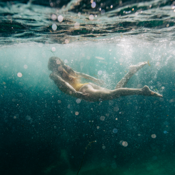 An underwater photo of a woman swimming in the sea