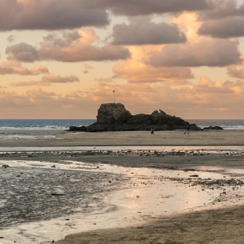 Looking across the sand to a rocky outcrop