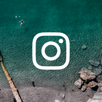 The Instagram logo set over an image of a woman swimming in a clear, green sea