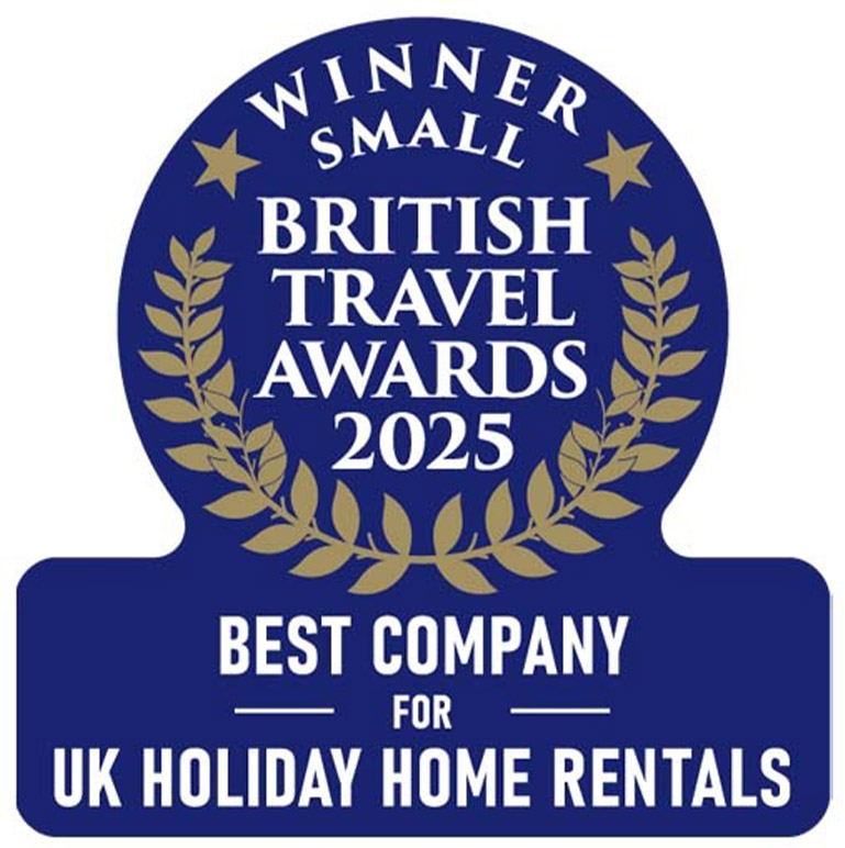 A logo with a blue background and gold leaf. White text reads: Winner Small Best Company for UK Holiday Home Rentals British Travel Awards 2025.
