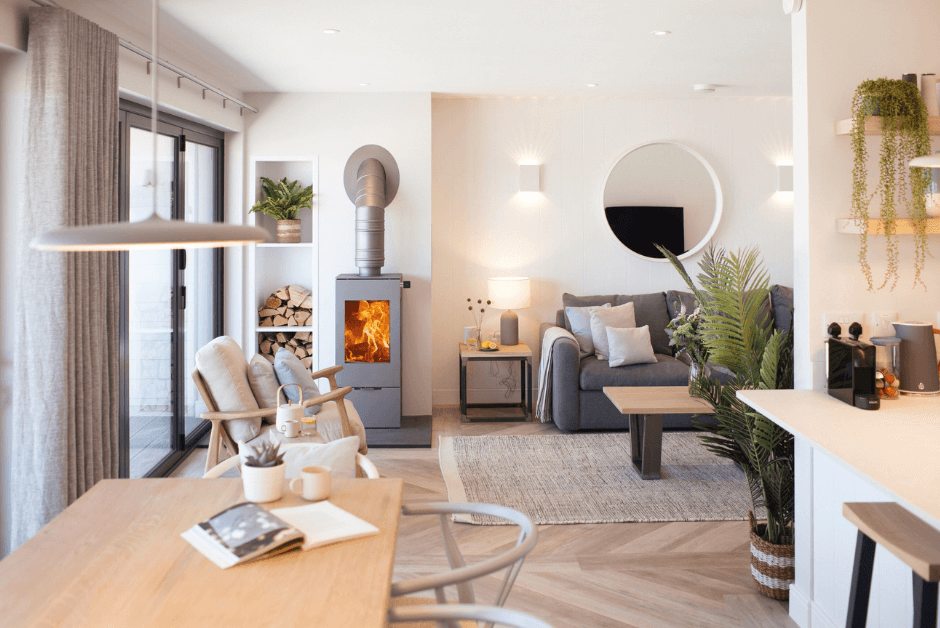 The contemporary living space, including wood burner and sofa, of Hideaway in Polzeath. 