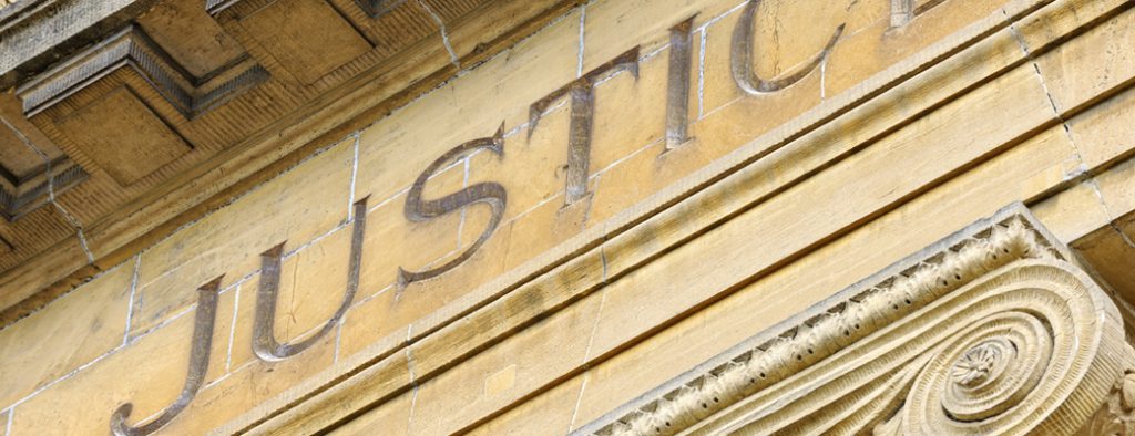 Der Schriftzug Justice prangt an einem alten Gebäude
