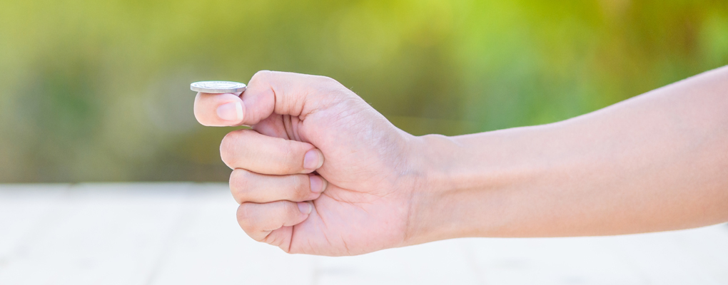 Eine Hand ist im Begriff, eine Münze zu werfen