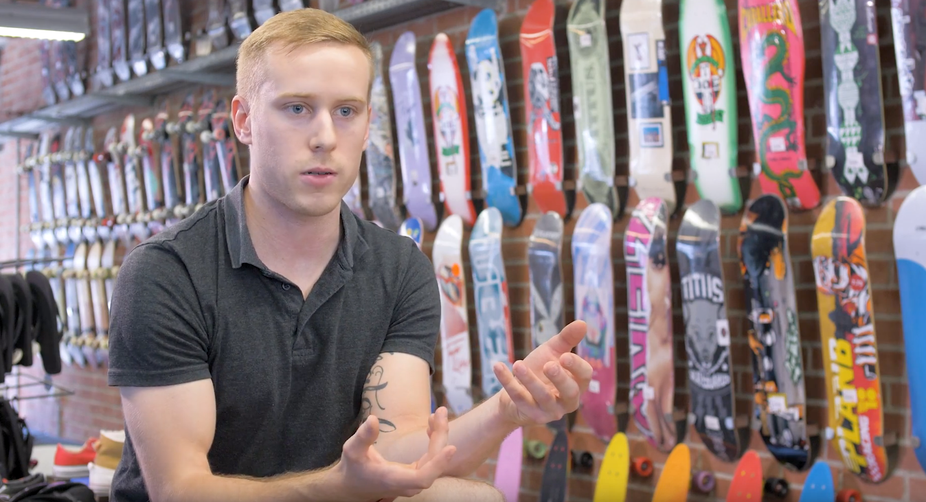 Ein Foto von einem Service-Mitarbeiter bei Titus, der vor dem Skateboardshop zur Kamera spricht