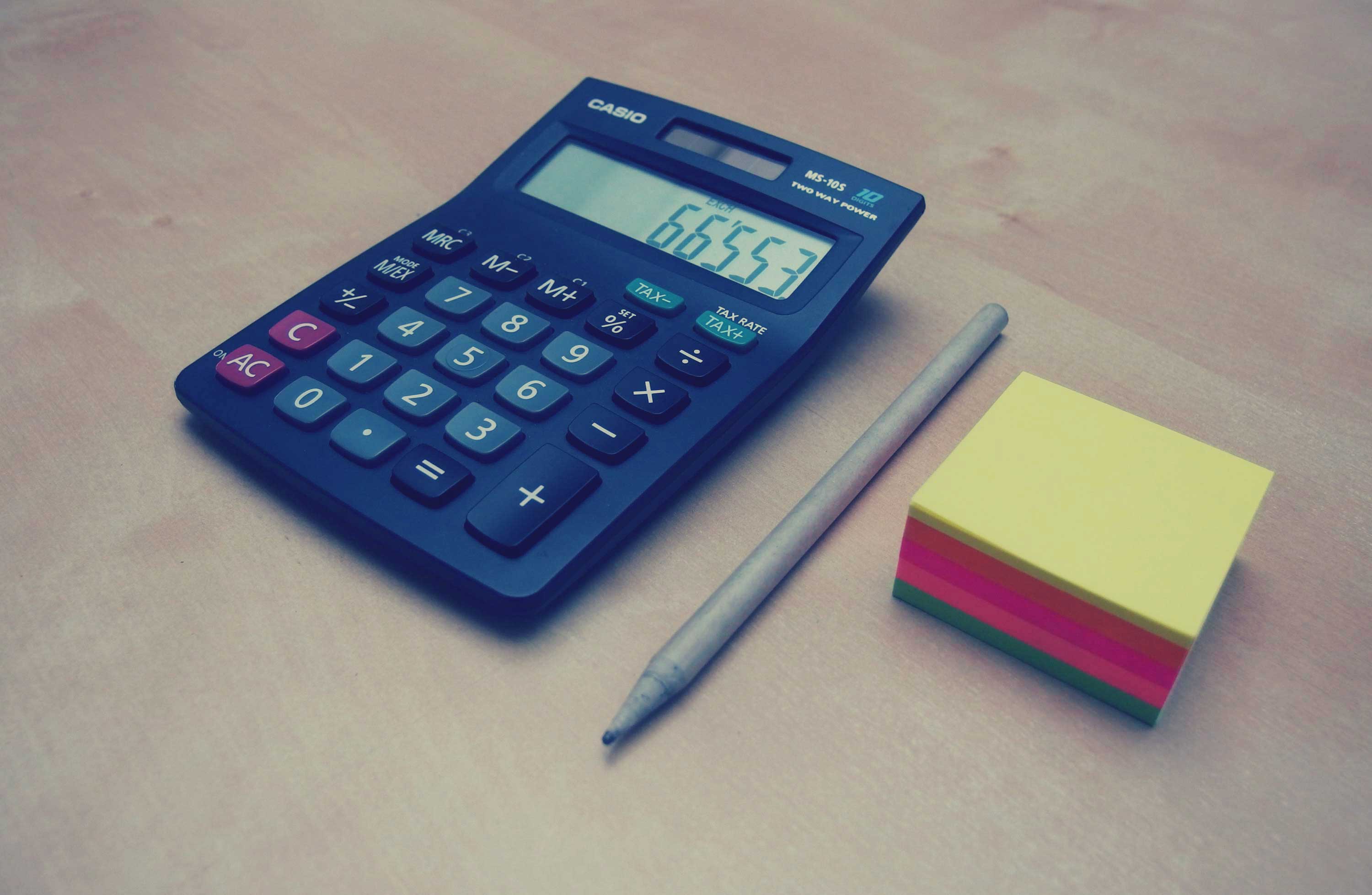 photograph picture of a calculator and notepads on a table