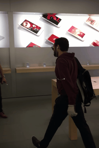 Gif zeigt Mann der auf ein neues Smartphone im Laden einschlägt