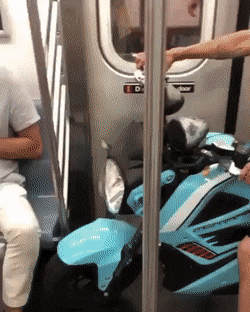 Gif zeigt Mann, der den Bahneingang ungeniert mit einem Roller versperrt