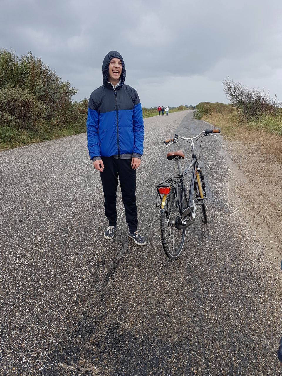 Fabian standing in the rain, laughing.
