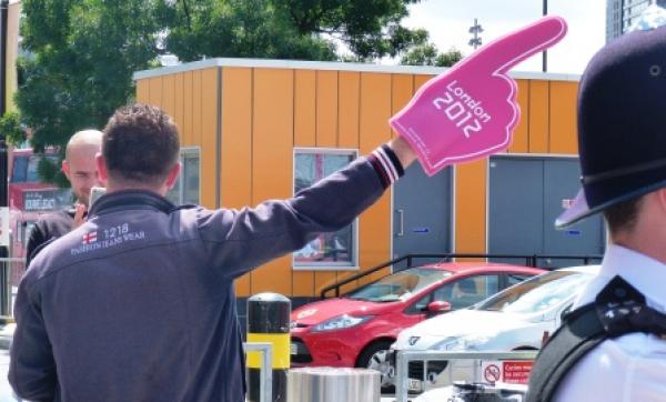 Man pointing with pink Olympic glove