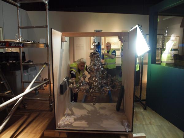 The chandelier is carefully lined up with the hoist.