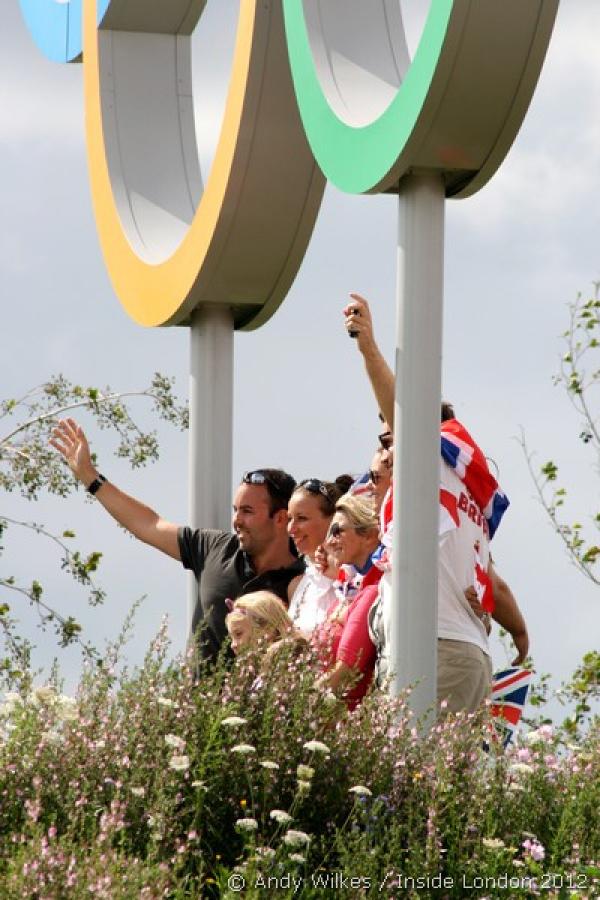 People sitting under Olympic rings