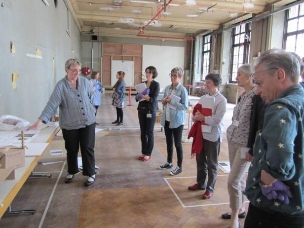 There must be some kind of ‘how many curators does it take to change a lightbulb/candlestick?’ joke to caption this photograph …