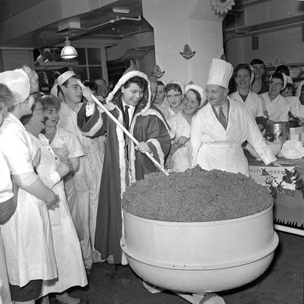 Photographic negative, Cliff Richard dressed with a santa's cape mixing a giant christmas pudding at J.Lyons, Cadby Hall, photographed by Harry Hammond, England, 1958. Museum no. S.14253-2009, © Victoria and Albert Museum, London