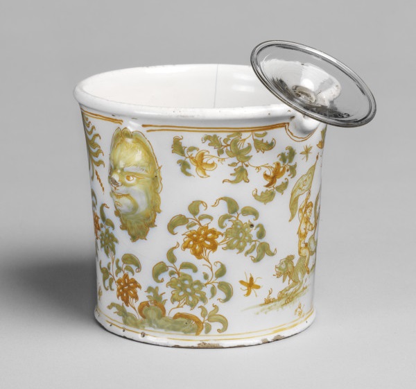 Tin-glazed earthenware wine glass cooler, cylindrical with two grotesque mask handles, Olérys and Laugier's pottery factory, Moustiers-Sainte-Marie, about 1739-1749 (V&A C.127-1930) © Victoria and Albert Museum, London