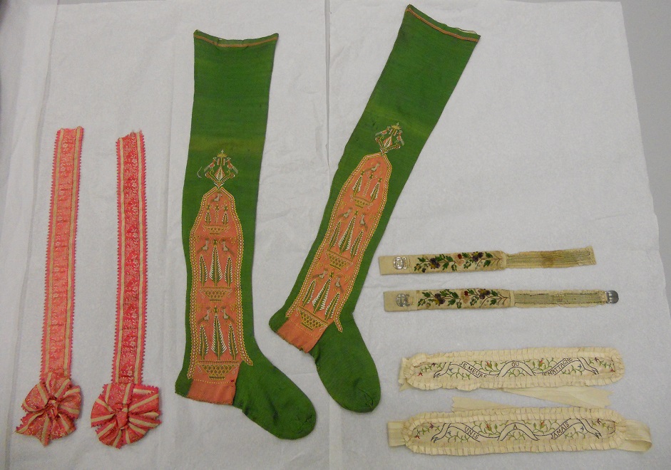 The assessments continue with a pair of 19th garters (T.1813-1913) and a pair of 18th century stockings (T.156-1971) © V&A Collection
