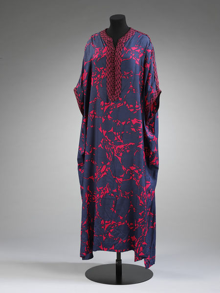 Female gandura (a garment that was initially only worn by men before Moroccan fashion designers introduced it for women in elegant fabrics and colours), made of a fluid printed silk and decorated with characteristic loop braids called sfifa. Designed by Naima Bennis, c. 1970. V&;A: ME.16-2015