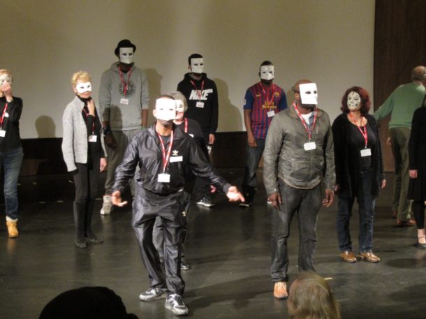A workshop of people learning movement and mask-wearing