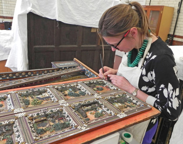 Furniture conservator Dana Melchar retouching a resin restoration