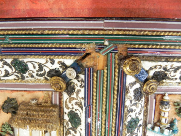 Corner of lamp-worked glass panel on lid during treatment