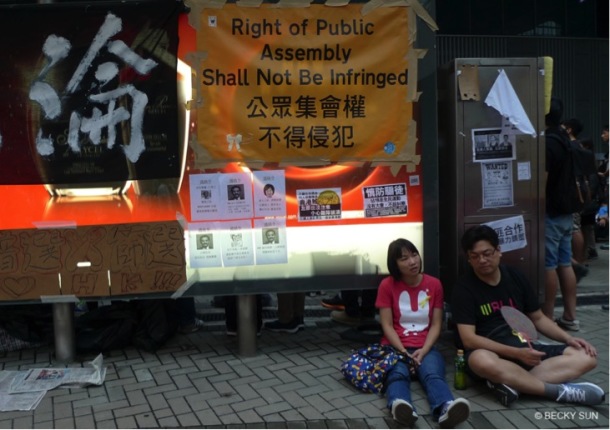 The yellow banner is a spoof on a similar yellow warning sign the police commonly use asking for protesters to retreat.