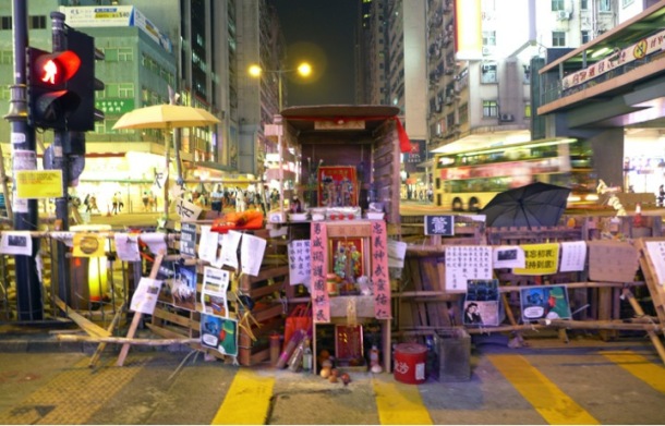 A Kwan Tai temple set up along a barrier in Nathan Road, Mong Kok. Kwan Tai is a warrior god revered by police in Hong Kong as well as allegedly triad members who are said to have a stake at the district. The temple was removed in the police action on 17 October. ©Becky Sun