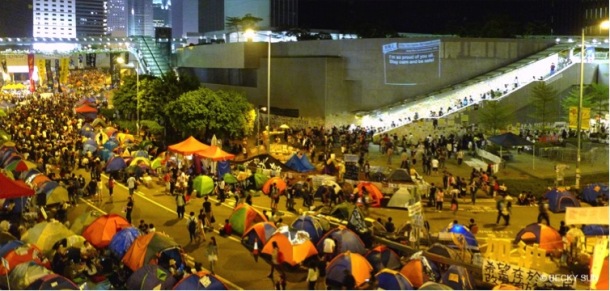 Around 2,300 tents have been propped up around the Central Government Offices in Admiralty, Hong Kong. The wall projection is “Add Oil Machine for HK Occupiers” by artists including Sampson Wong Yu-hin and Jason Lam, which displays support messages collected via a website they custom built. Photograph by Becky Sun. © Becky Sun
