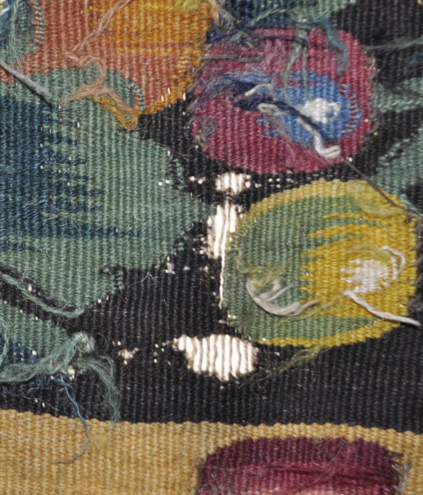 The back of the tapestry. The dark brown weft threads have disintegrated, exposing the white warp threads beneath © Victoria and Albert Museum, London