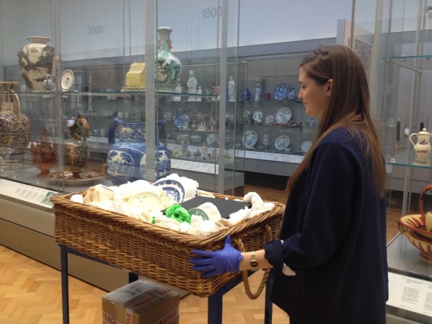 Florence pushing a trolley of objects through the gallery