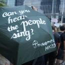 One of the umbrellas with calligraphy by Savona Ling, outside the first “Democracy Wall” on the tall fences encircling the Civic Square in the background. Civic Square, whose name was so given in a student movement against nationalist education in 2012, was fenced off in recent months for added security to the Central Government Offices.