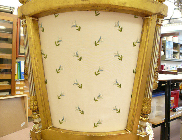 Detail of the brass clips holding the upholstered stretcher back in place and protected so as not to abrade the gilded surface