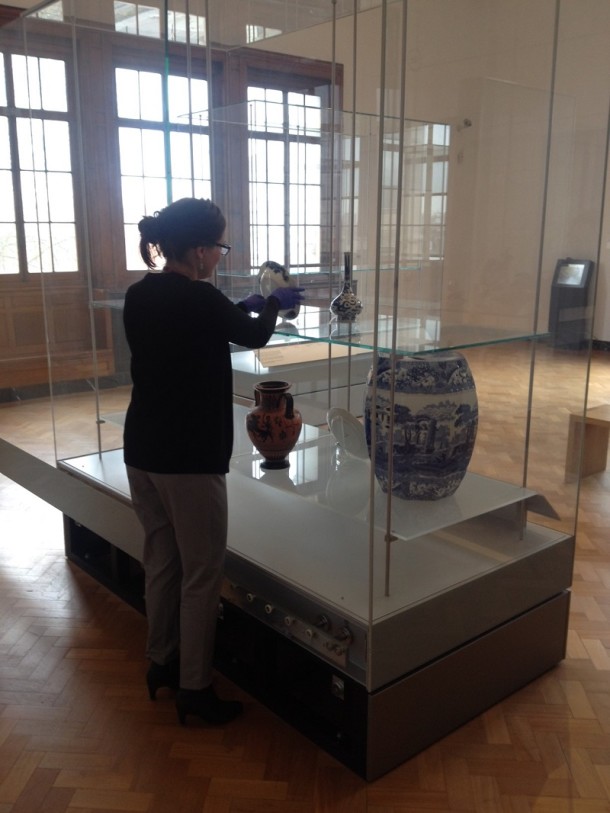 Rebecca places objects onto the shelves