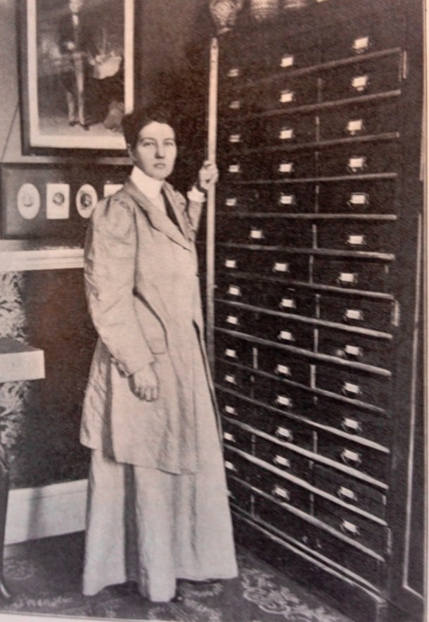 Enthoven at home with cabinets holding her collected materials, about 1909.