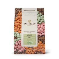 a bag of barry callebaut lemon chocolate callets with a pile of green chocolate callets on the side, chips, chunks