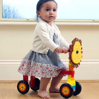 child playing on wooden Lion Trike