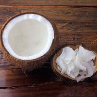 a coconut with a bowl of coconut flakes