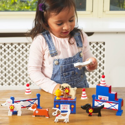 child playing with wooden dog show play set
