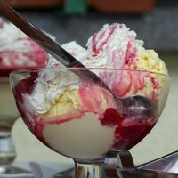 raspberry topping with ice cream in a glass bowl with a spoon