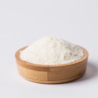 a wooden bowl of white creamy beige milk powder