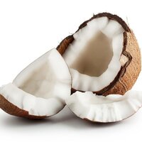 a whole coconut cut in half with coconut pieces