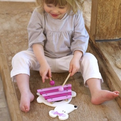 child playing with wooden xylophone