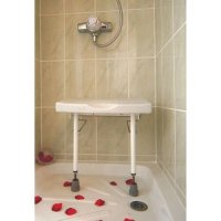 Drop down wall mounted shower seat with a stainless steel frame.