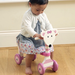 child riding on wooden pink trike