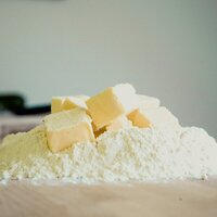 pieces of butter piled on top of heap of flour