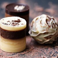 millionaire truffle pieces, two cylindrical chocolate truffles and one sphere chocolate truffle, white, dark and milk chocolate