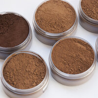 metal tins cans cups filled with cocoa powders of different shades of brown