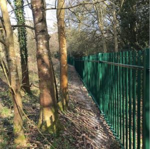 Caption: Green powder-coated steel palisade fencing