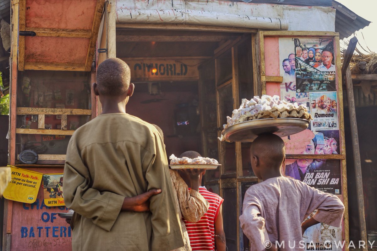 Groundnut sellers watching TV during their break time after hawking at Tashan Bama area Maiduguri.