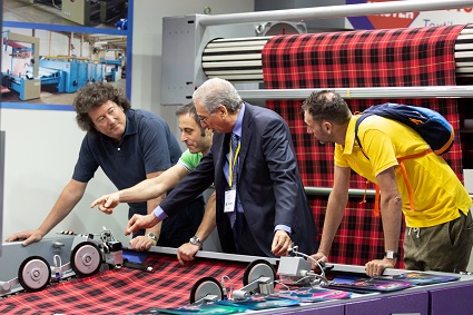 examining fabric at ITMA