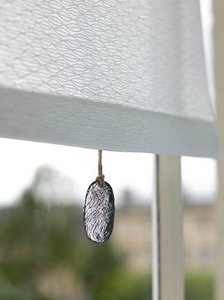 pewter pebble blind pull in a window